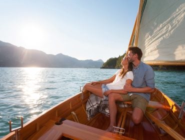 Paar genießt die Sonne beim Segeln vom Boot aus.