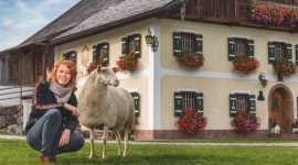 Mädchen mit Schaf vorm Bauernhof