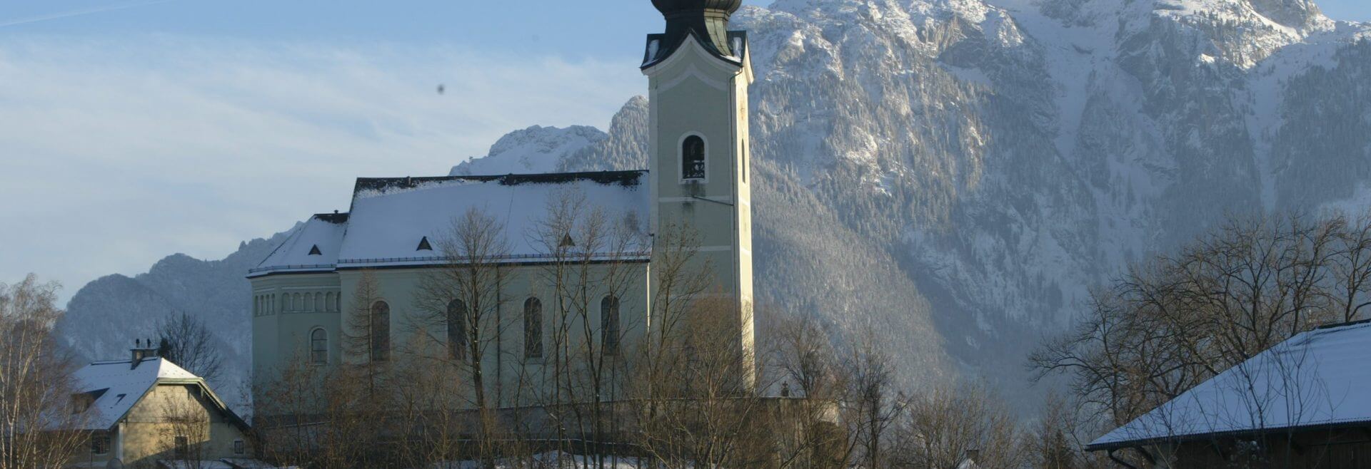 Die Schnee bedeckte Kirche von Wals-Siezenheim - im Hintergrund der Untersberg