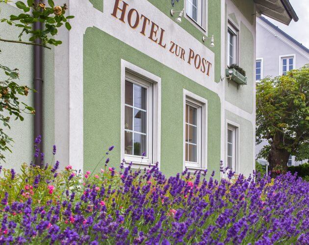 Hausfassade des Hotels zur Post mit blühendem Lavendel im Vordergrund