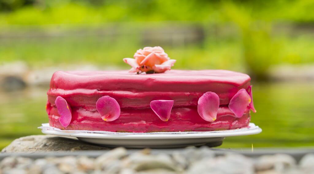 Torte mit rosa Glasur und Rosenblättern