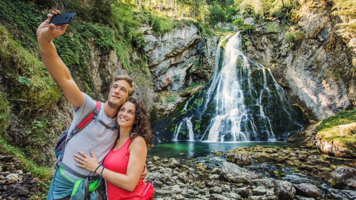 Junges Paar macht ein Selfie vor dem Gollinger Wasserfall