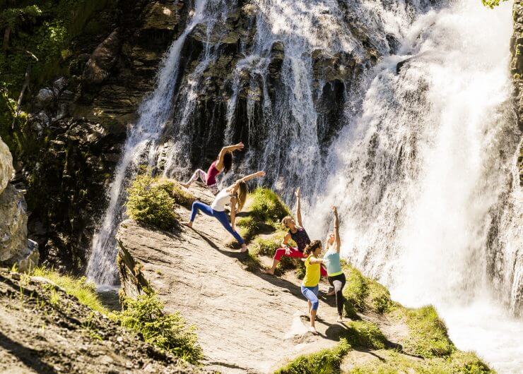 Eine Gruppe macht Yoga am Wasserfall
