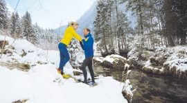 Pärchen macht Stretching nach einem Lauf im Schnee