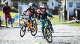 Kinder mit Helm am Mountainbike im Bikepark